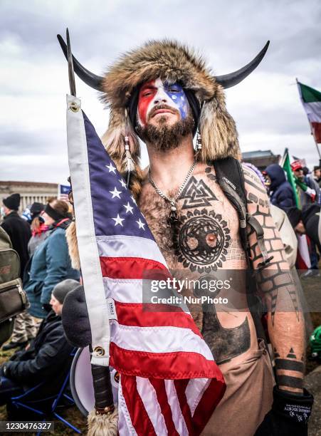 Portrait of Jake Angeli, a QAnon supporter known for his painted face and horned hat outside the US Capitol following a "Stop the Steal"...