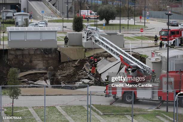 Two firefighters descend into the huge chasm that opened, following an explosion, in the parking lot of the Ospedale del Mare in Naples, in the...