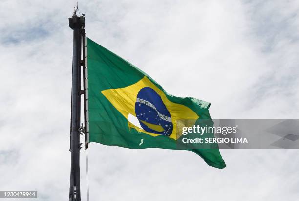 Torn Brazilian national flag flutters in the wind on the tallest flag pole in the world at the Three Powers Square in Brasilia as seen from Planalto...
