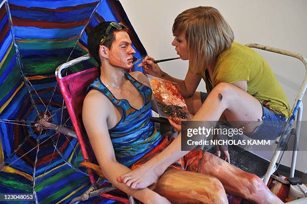 Artist Alexa Meade paints model Will Claybaugh during a performance at the Irvine Contemporary gallery in Washington on August 20, 2011. Meade paints...