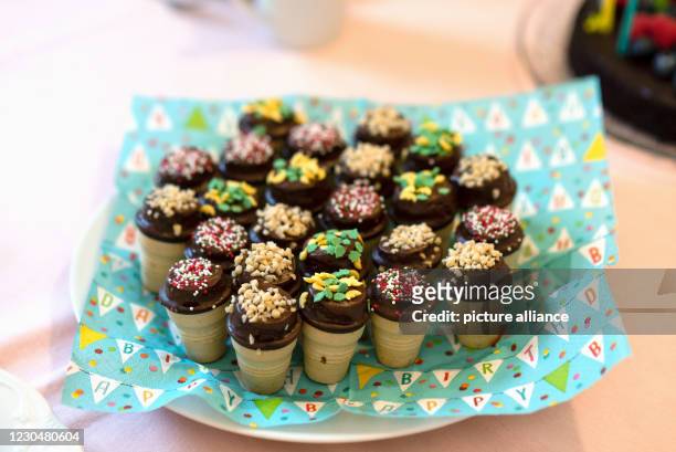 December 2020, Saxony-Anhalt, Magdeburg: On a plate are muffins in a waffle cup. They are decorated with colorful sprinkles. Photo: Stephan...