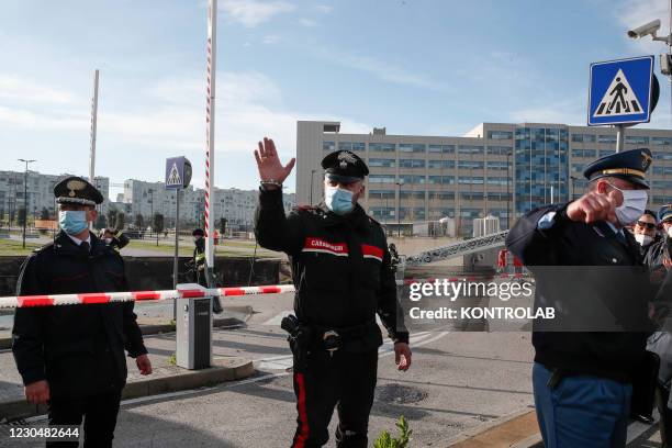 Italian carabinieri patrol the check point in front of the huge chasm, 2500 meter square for 15 meter deep, caused by explosion of hospital oxigen...