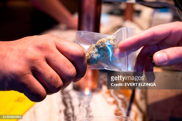 Customer buys marijuana in a coffee shop in the city centre of Amsterdam on January 8, 2021. - Amsterdam's ecologist mayor on January 8 proposed...