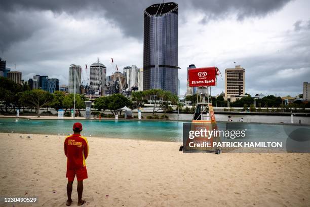Lifeguard stands watch over a deserted South Bank beach on the first day of a snap lockdown in Brisbane on January 9 with officials elsewhere in...