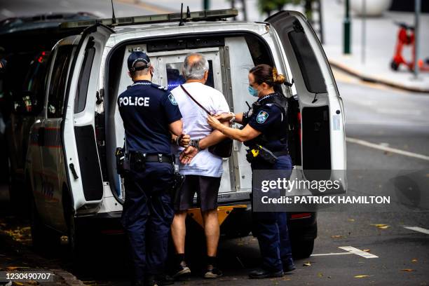Police arrest a man for resisting to wear a face mask on the first day of a snap lockdown in Brisbane on January 9 with officials elsewhere on "high...