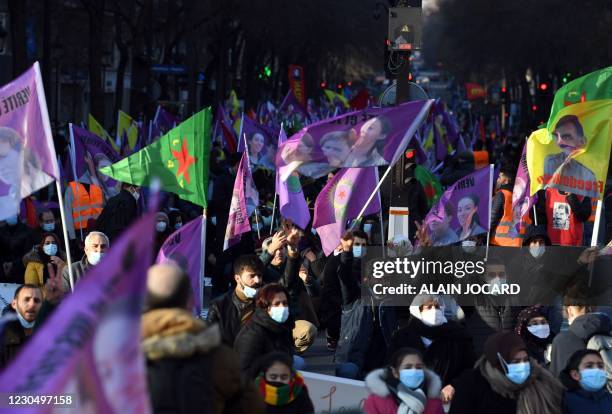 Kurdish supporters wave portraits and flags as they protest, on January 9, 2021 in Paris, in memory of three Kurd activists murdered in Paris eight...