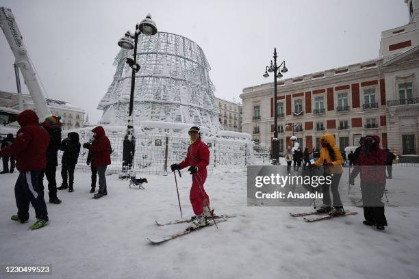 People walk and ski on snow covered road at Puerta del Sol as they enjoy during heavy snowfall in Madrid, Spain on January 09, 2021. Spain is on red...