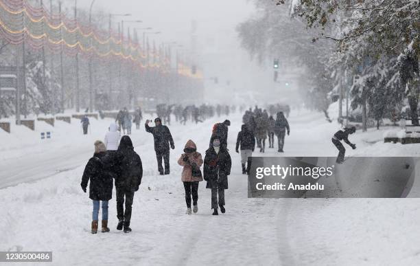 People walk and ski on snow covered road at city center as they enjoy during heavy snowfall in Madrid, Spain on January 09, 2021. Spain is on red...