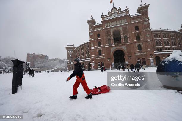 People walk and ski on snow covered road at city center as they enjoy during heavy snowfall in Madrid, Spain on January 09, 2021. Spain is on red...