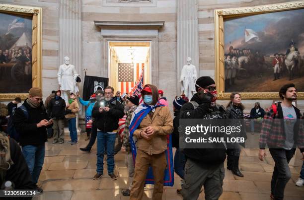 Supporters of US President Donald Trump walk around in the Rotunda after breaching the US Capitol in Washington, DC, January 6, 2021. Demonstrators...