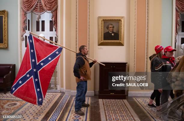 Supporter of US President Donald Trump holds a Confederate flag outside the Senate Chamber during a protest after breaching the US Capitol in...