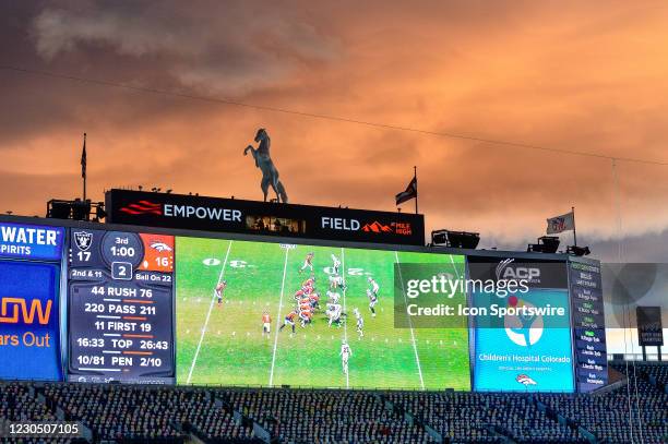 Cardboard cutouts of South Park cartoon characters are seen in the south stands of the stadium as the sun sets and the game is projected on the...