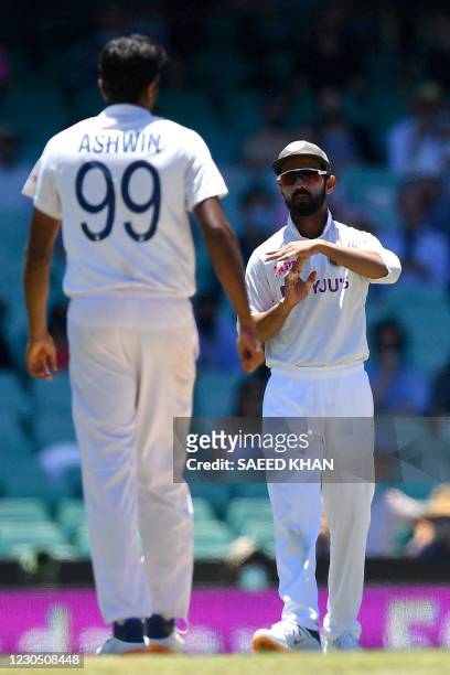 Indian captain Ajinkya Rahane requests a third umpire decision from a Ravichandran Ashwin leg before wicket appeal against Australian batsman Steve...