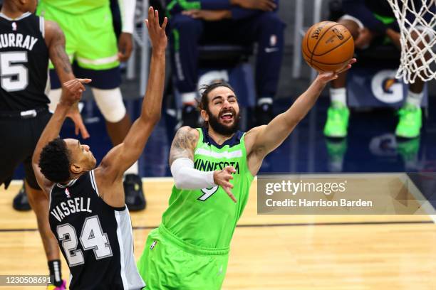 Ricky Rubio of the Minnesota Timberwolves attempts to score during the fourth quarter as Devin Vassell of the San Antonio Spurs guards him at Target...