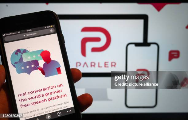 January 2021, Berlin: On a mobile phone, the website of the social media platform Parler is displayed. The platform's logo is on a screen in the...