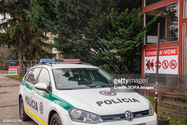 Police vehicle seen driving past Covid-19 signs at the guarded entrance to the mass-testing hospital's point in Nitra's FN hospital. As the Covid-19...