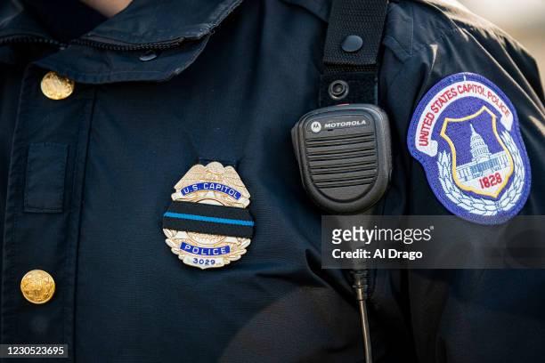 Capitol Police officer wears a mourning band over his badge following a police procession of the hearse carrying the casket of Brian Sicknick, U.S....