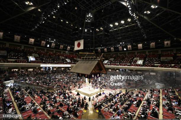 This picture taken on January 10, 2021 shows people attending the first day of the Grand Sumo Tournament at Ryogoku Kokugikan arena in Tokyo. / Japan...