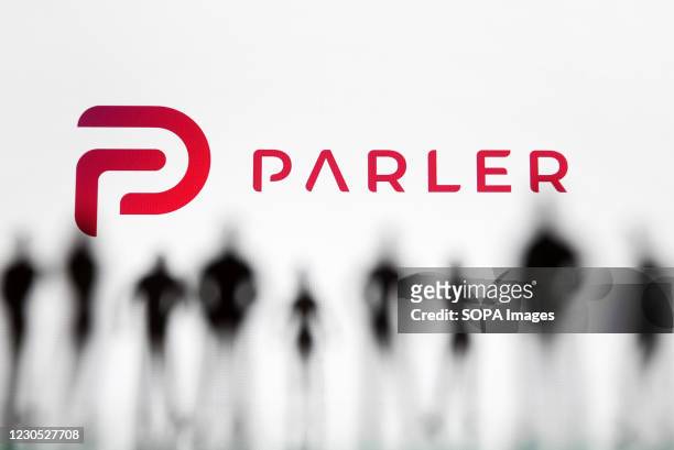 In this photo illustration the Parler logo seen in front of the silhouettes of toy people. Google, Apple and Amazon have suspended the social...
