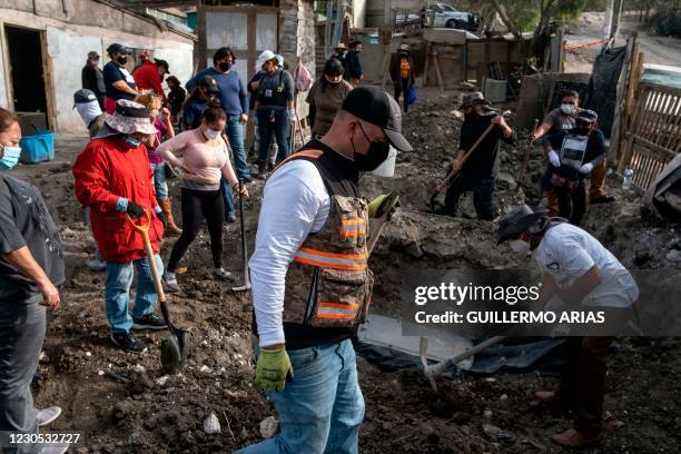 Members of a group searching for missing people search human remains at a yard of a house located on the Maclovio Rojas area in Tijuana, Mexico, on...