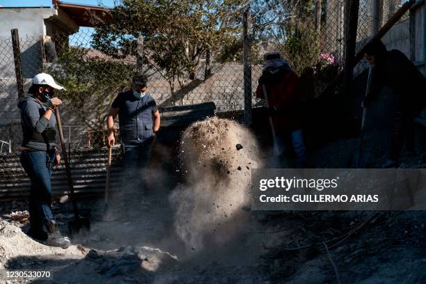 Members of a group searching for missing people dig to find human remains at a yard of a house located on the Maclovio Rojas area in Tijuana, Mexico,...