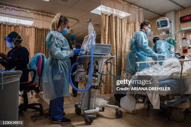 Health care workers tend to a Covid-19 patient in a Covid holding pod at Providence St. Mary Medical Center in Apple Valley, California on January...