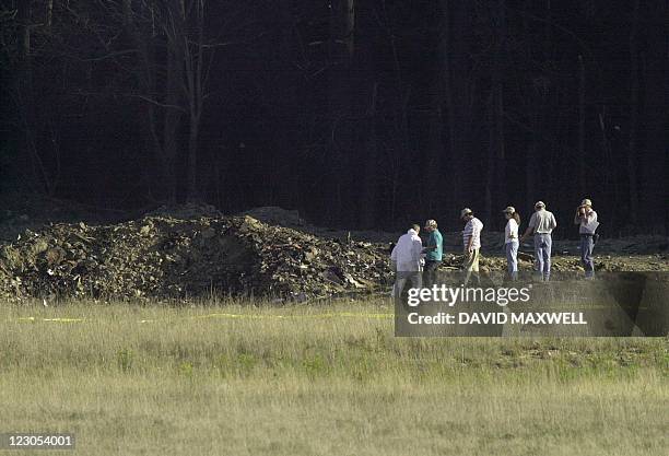 Officials examine the crater 11 September 2001 at the crash site of United Airlines Flight 93 in Shanksville, Pennsylvania. The plane from Newark,...