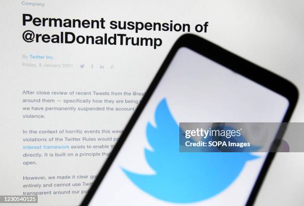 In this photo illustration, a 'Permanent suspension of @realDonaldTrump' message seen on a Twitter website in front of a mobile phone with a Twitter...