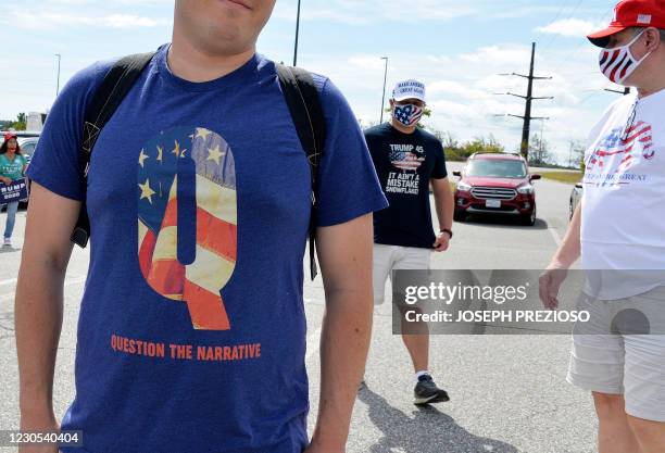 Man wears a QAnon shirt while boarding a shuttle bus at the Manchester Mall going to Manchester Airport in Londonderry, New Hampshire on August 28,...