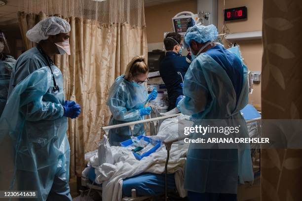 Healthcare workers tend to a patient with Covid-19 who is having difficulty breathing in a Covid holding pod at Providence St. Mary Medical Center in...