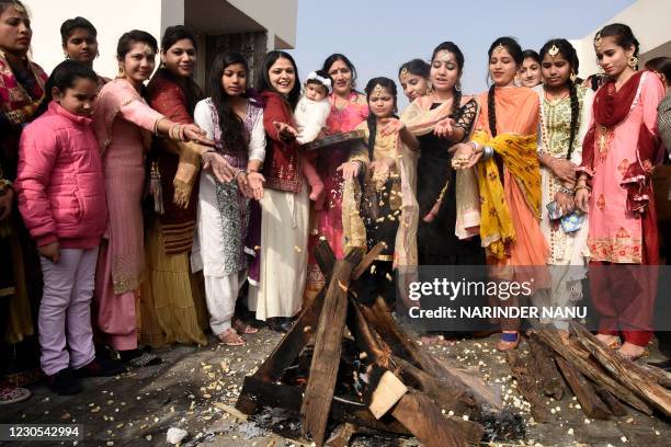 Students clad in traditional Punjabi dresses throw sweets, groundnuts, puffed rice, and popcorn into a bonfire that symbolises Agni, the Hindu deity...