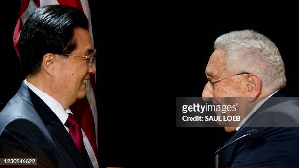 Chinese President Hu Jintao stands alongside former US Secretary of State Henry Kissinger after being introduced prior to speaking during a luncheon...