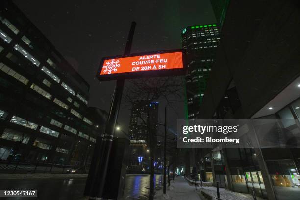 Sign reading "Alert Curfew From 20H to 5H" on Rene Levesque Boulevard during curfew hours in downtown Montreal, Quebec, Canada, on Monday, Jan. 11,...