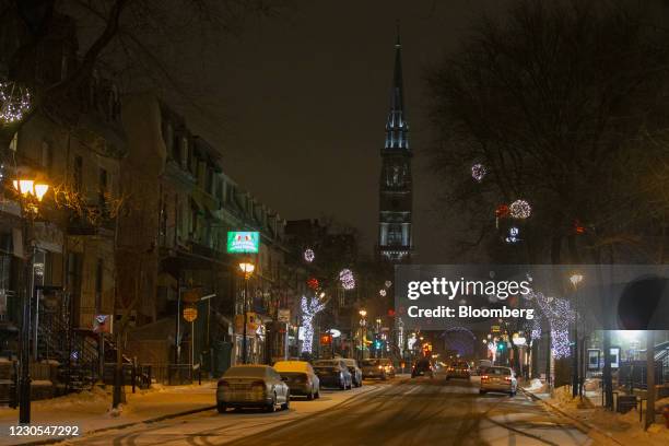 Vehicles drive on Saint Denis Street during curfew hours in Montreal, Quebec, Canada, on Monday, Jan. 11, 2021. Quebec has implemented a curfew,...