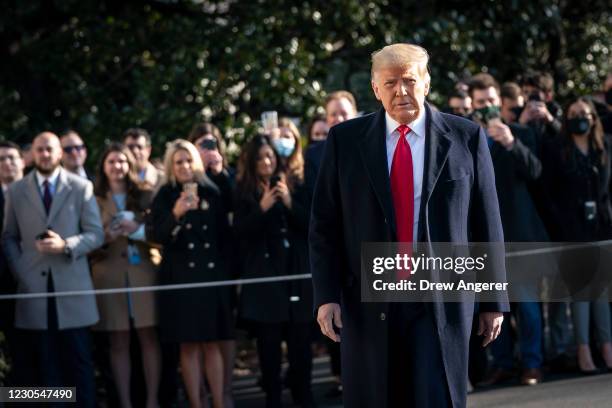 President Donald Trump turns to reporters as he exits the White House to walk toward Marine One on the South Lawn on January 12, 2021 in Washington,...