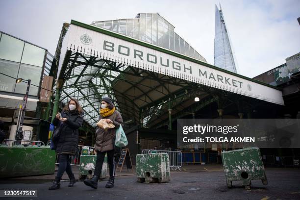 Customers wear face masks because of the coronavirus pandemic as they shop at Borough Market in London on January 12, 2021. - Borough market, an...