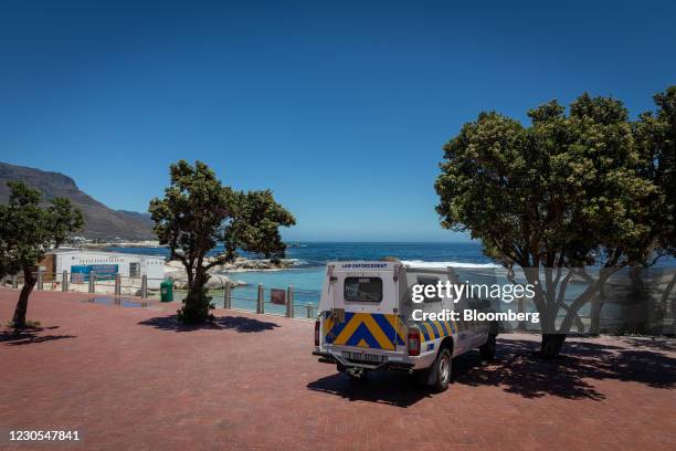 Police vehicle patrols the empty Camps Bay beach, closed due to Covid-19 regulations, in Cape Town, South Africa, on Monday, Jan. 11, 2021. The...