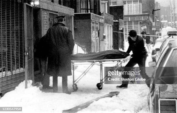 Boston Police remove the body of a shooting victim from a Chinatown social club in Boston on Jan. 12, 1991. Five men playing cards at the after-hours...