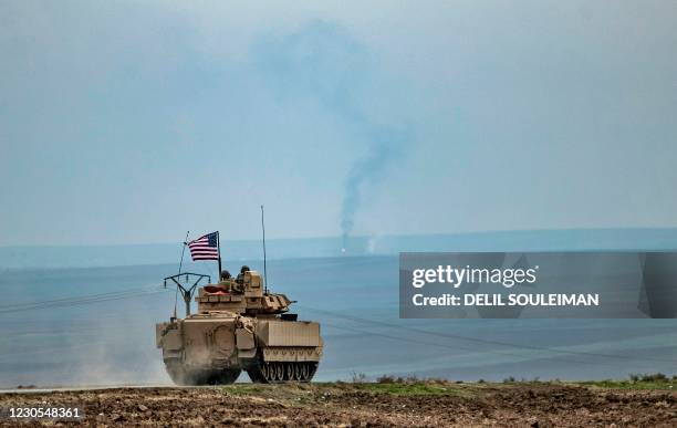 Soldiers in a Bradley tank patrol an area near Syria's northeastern Semalka border crossing with Iraq's Kurdish autonomous territory, on January 12,...