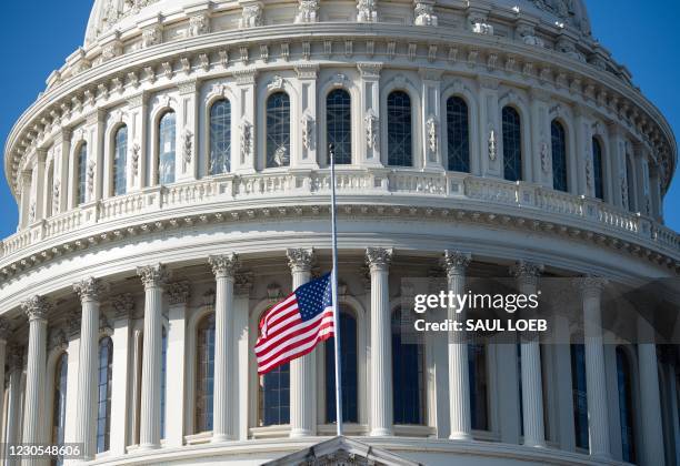 The outside of the US Capitol is seen with a US flag at half-staff in Washington, DC, January 12 ahead of a House vote calling on US Vice President...