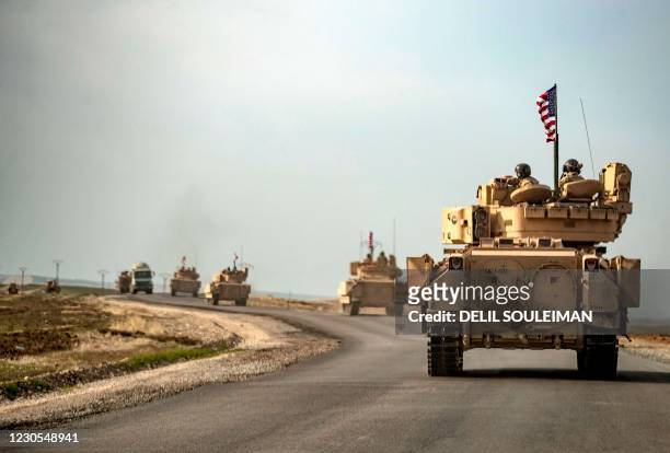 Soldiers in Bradley tanks patrol an area near Syria's northeastern Semalka border crossing with Iraq's Kurdish autonomous territory, on January 12,...