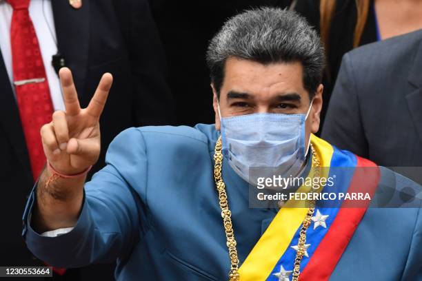 Venezuelan President Nicolas Maduro flashes the V sign as he arrives at the Congress to present the annual report of his government before the...