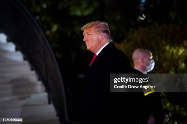 President Donald Trump walks to the White House residence after exiting Marine One upon his return on January 12, 2021 in Washington, DC. Following...
