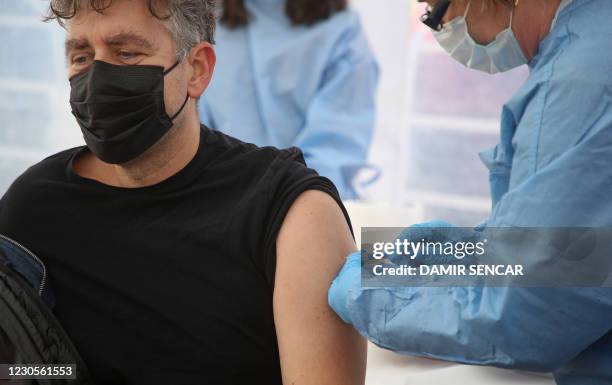 Medical worker vaccinates a man with the Moderna Covid-19 vaccine, in a Red Cros medical tent in Petrinja, some 50 kilometres from Zagreb, on January...