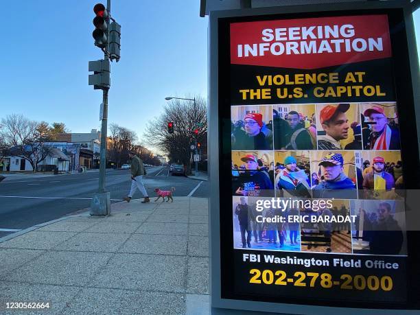 Poster distributed by the FBI seeking information on violent US President Donald Trump supporters, is seen displayed at a bus stop kiosk on a...