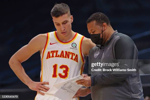 Bogdan Bogdanovic talks with Assistant Coach, Melvin Hunt during the game against the Charlotte Hornets on January 9, 2021 at Spectrum Center in...