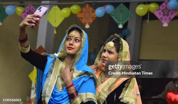 Students click a selfie amid Lohri festival celebrations at Shahzada Nand College on January 13, 2021 in Amritsar, India.