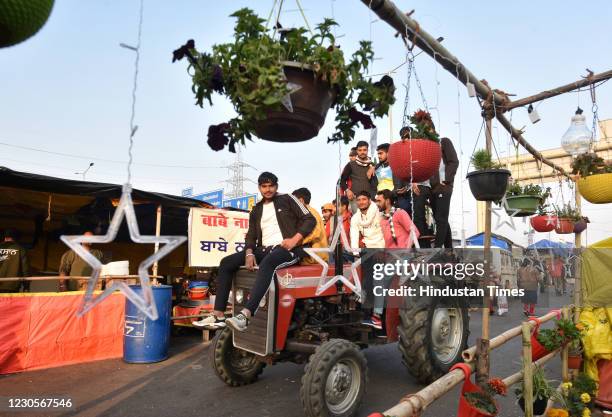 Farmers ride a tractor during Lohri festival amid the ongoing protest against the new farm laws, at Ghazipur on January 13, 2021 in New Delhi, India.