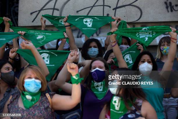 Feminist activists hold up green handkerchiefs -in favour of the decriminalization of abortion- and their clenched fists during a demonstration in...