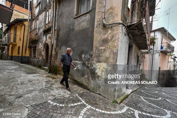 Resident walks across a street of the old center in the town of Cinquefrondi in Calabria region in south Italy, on July 6, 2020. - Italian juvenile...